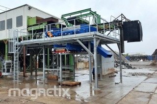 Installation of an eddy current separator with a supporting structure and service platforms in a waste sorting plant in Germany.